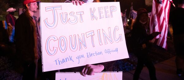 Una mujer con la pancarta Sólo siguen contando - Sputnik Mundo