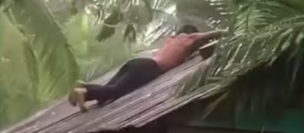 Un hombre se subió al techo de su vivienda para repararlo durante una tormenta - Sputnik Mundo