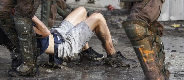 Carabineros deteniendo a una persona durante una manifestación - Sputnik Mundo