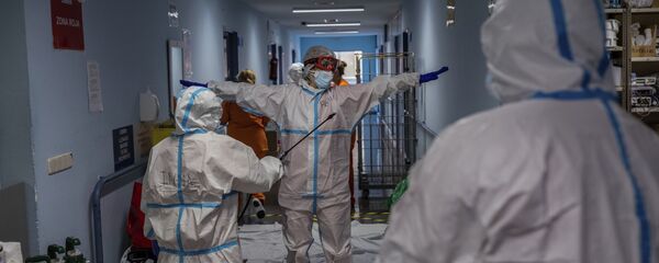 Un miembro del equipo médico es desinfectado antes de salir de la sala COVID-19 del hospital Severo Ochoa en Leganés, en las afueras de Madrid, España.  - Sputnik Mundo