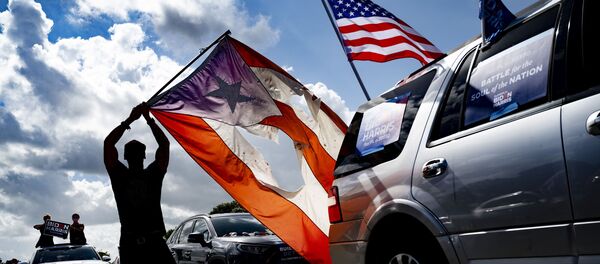 Un hombre con las banderas de Puerto Rico y EEUU - Sputnik Mundo