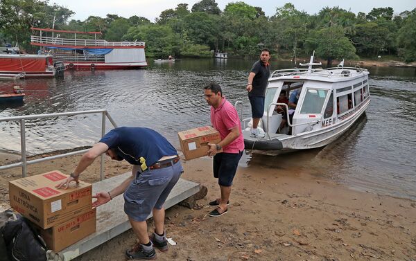 Trabajadores electorales desembarcan las urnas electrónicas que serán utilizadas en las elecciones municipales del domingo en Brasil - Sputnik Mundo