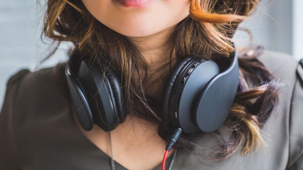 Mujer en auriculares (foto referencial) - Sputnik Mundo