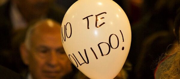 Mujer sostiene globo con la frase No te olvido - Sputnik Mundo