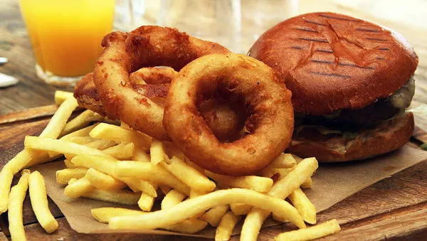 Un plato con aros de cebolla, patatas fritas y una hamburguesa - Sputnik Mundo
