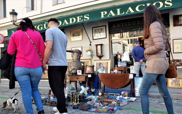 Varias personas miran un puesto del Rastro de Madrid - Sputnik Mundo
