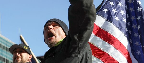 Un hombre con la bandera de EEUU - Sputnik Mundo
