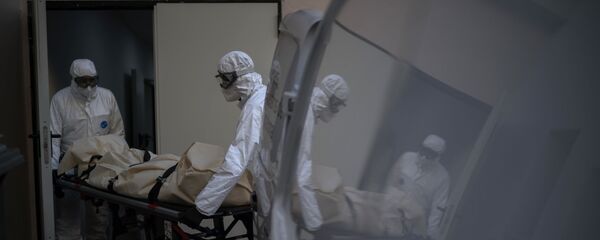 Trabajadores de una morgue recogen el cuerpo de una víctima de COVID-19 de un hogar de mayores en Barcelona, ​​España.  - Sputnik Mundo
