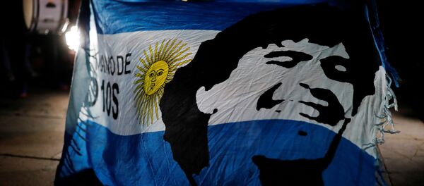 Una bandera de Argentina con el retrado de Maradona - Sputnik Mundo
