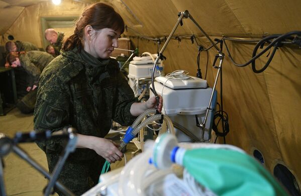 Los médicos militares están orientados en primer lugar en el servicio médico de las fuerzas de paz, pero además están dispuestos a ayudar a los residentes de la república. En la foto: militares rusos montan equipo médico en el hospital de campaña móvil cerca de Stepanakert - Sputnik Mundo