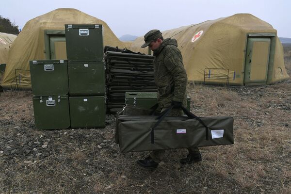 Más de 20.000 refugiados han regresado a la no reconocida República de Nagorno Karabaj después de la desescalada del conflicto militar. Anteriormente se informó de que la primera escuela, restaurada con la ayuda del Ministerio de Situaciones de Emergencia de Rusia en Nagorno Karabaj, se está preparando para recibir a los estudiantes.En la foto: un militar ruso descarga el equipo médico en el hospital de campaña móvil cerca de Stepanakert.  - Sputnik Mundo