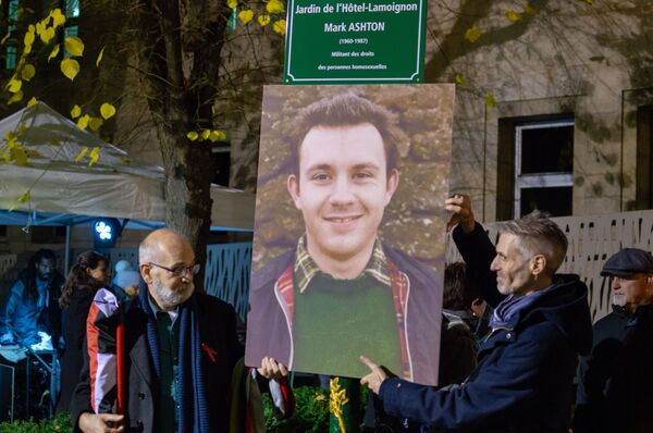 Dos hombres sujetan la foto del militante del Partido Comunista del Reino Unido y activista del movimiento LGBT Mark Ashton - Sputnik Mundo