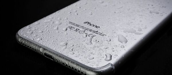 Un iPhone con gotas de agua (imagen referencial) - Sputnik Mundo