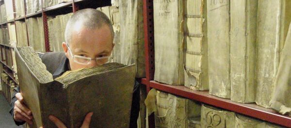 Profesor Matija Strlic oliendo un libro antiguo en el Archivo Nacional de Países Bajos - Sputnik Mundo