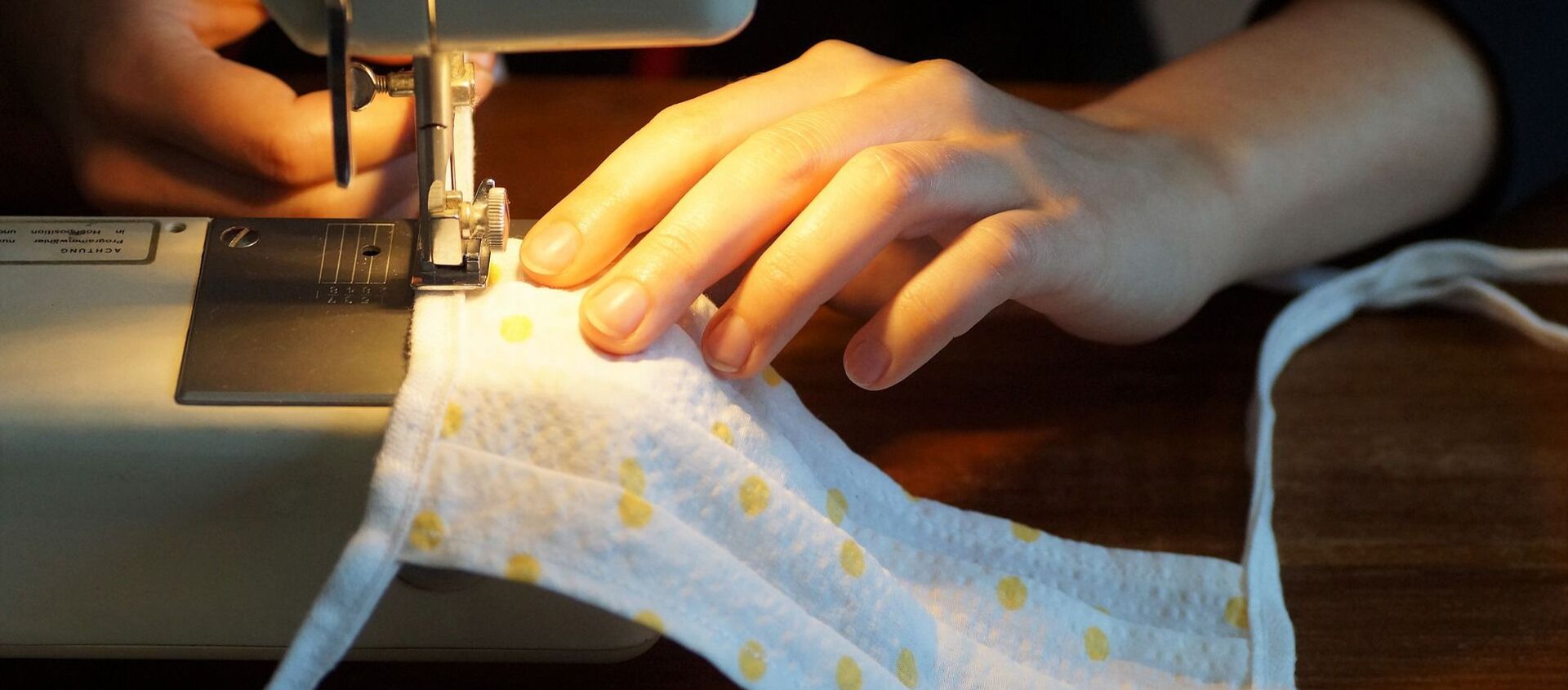 Una mujer cose una mascarilla de tela, referencial - Sputnik Mundo, 1920, 08.12.2020