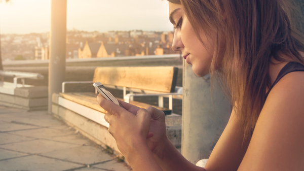 Una joven mira su teléfono, referencial - Sputnik Mundo