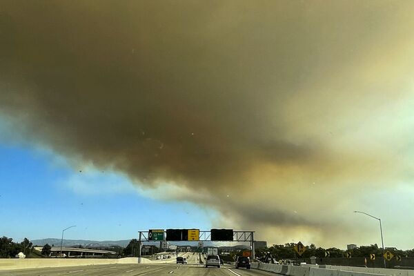Las llamas se difunden impetuosamente debido a una baja humedad aérea y un fuerte viento, sus ráfagas alcanzan los 30 metros por segundo.En la foto: el humo sobre la carretera 22 debido a los incendios en California. - Sputnik Mundo