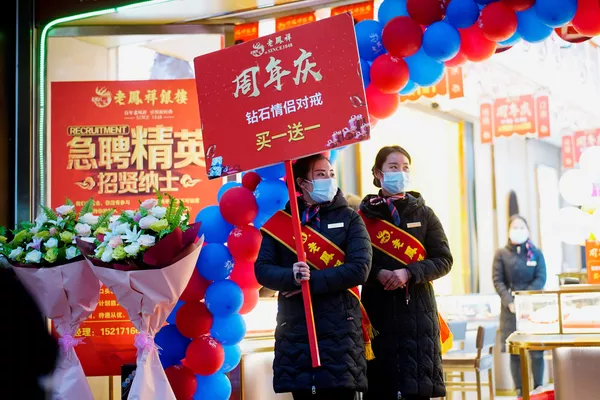 Los vendedores de una de las joyerías de Wuhan realizan sus habituales campañas publicitarias en las calles con mascarillas. Los vendedores de una de las joyerías de Wuhan realizan sus habituales campañas publicitarias en las calles con mascarillas. - Sputnik Mundo