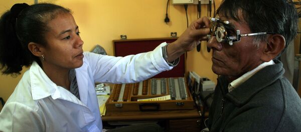 Médica oftalmóloga cubana atendiendo a un paciente en Bolivia - Sputnik Mundo
