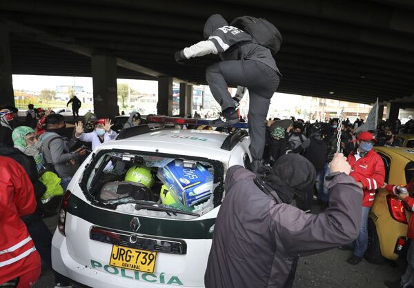 Manifestantes avanzan sobre un coche de Policía durante una manifestación en noviembre de 2020 Manifestantes avanzan sobre un coche de Policía durante una manifestación en noviembre de 2020 - Sputnik Mundo