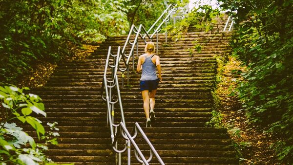 Una mujer sube las escaleras, imagen referencial - Sputnik Mundo