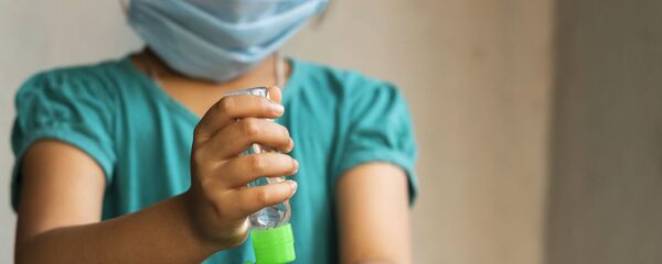 Niña colocándose alcohol en gel en las manos - Sputnik Mundo