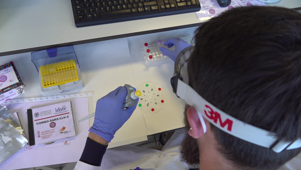 Investigadores de la UPV realizando las pruebas COVID con un DVD modificado - Sputnik Mundo