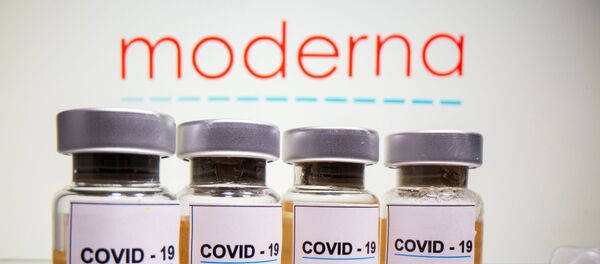 Unos frasco de vacunas y el logotipo de la companía Moderna - Sputnik Mundo