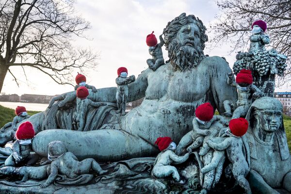 Pequeñas estatuas de bronce que representan a los Niños del Nilo con sombreros y máscaras navideñas. Esta escultura se encuentra en Copenhague, Dinamarca, y es una réplica de una obra de un antiguo maestro que representa la personificación del gran río Nilo egipcio. El original es de mármol y está en el Vaticano. - Sputnik Mundo