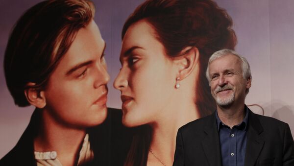 El director James Cameron junto con el poster de 'Titanic' - Sputnik Mundo