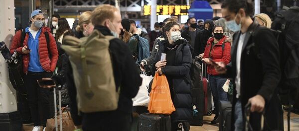 La gente espera en el vestíbulo de la estación de Paddington en Londres, después del anuncio de que la capital se someterá a las restricciones de nivel 4 contra el COVID-19. - Sputnik Mundo