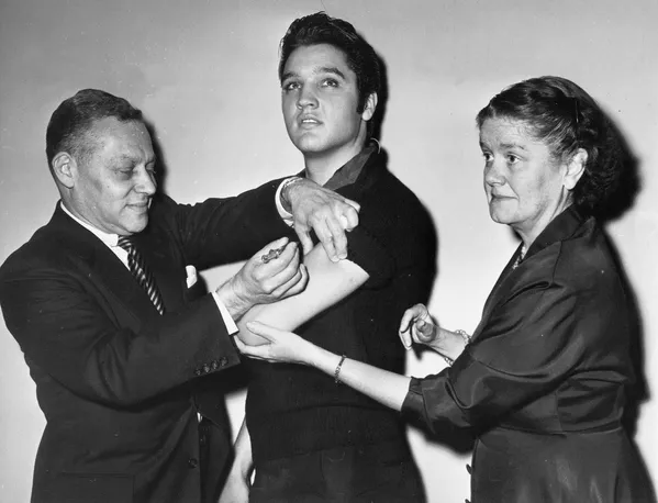 El cantante estadounidense Elvis Presley durante la vacunación contra la poliomielitis en Nueva York, 1956. El cantante estadounidense Elvis Presley durante la vacunación contra la poliomielitis en Nueva York, 1956. - Sputnik Mundo