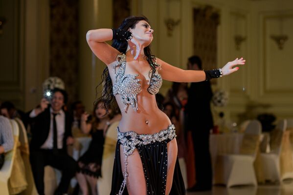 En su forma actual, la danza del vientre apareció a finales del siglo XIX. Era un arte escénico que se basaba mucho en el ballet y en los estilos de baile de la época. En la foto: una bailarina de Marruecos baila la danza del vientre en una boda en El Cairo.   - Sputnik Mundo