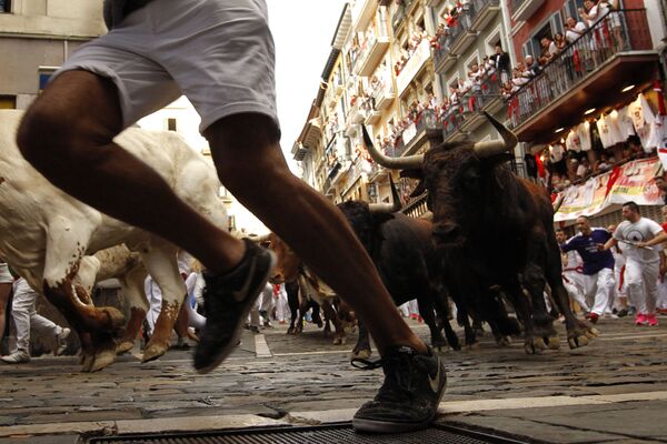 Durante siglos, la fiesta de San Fermín, capital navarra de Pamplona se ha caracterizado por ser un espectáculo para ver como los toros y la gente corren por las estrechas calles de la antigua ciudad. En la foto: los toros corren tras las personas durante el festival de San Fermín en Pamplona, España, 2018. - Sputnik Mundo