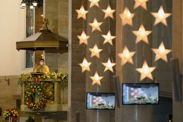 Un sacerdote celebra de manera creativa y con tecnología la misa de Navidad en la catedral de Manila, Filipinas. - Sputnik Mundo