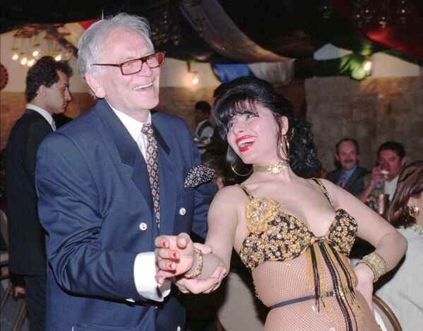 En 1968, Cardin comenzó a producir artículos que no estaban vinculados con el mundo de la moda, como la porcelana. Era un gran aficionado a los inmuebles y propietario de varios edificios ubicados en el VIII Distrito de París, a las afueras del Palacio del Elíseo. En la foto: Cardin junto a una bailarina en el hotel Taybet de Petra (Jordania), en 1996. - Sputnik Mundo