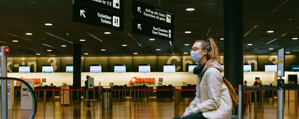 Una mujer en mascarilla en el aeropuerto - Sputnik Mundo