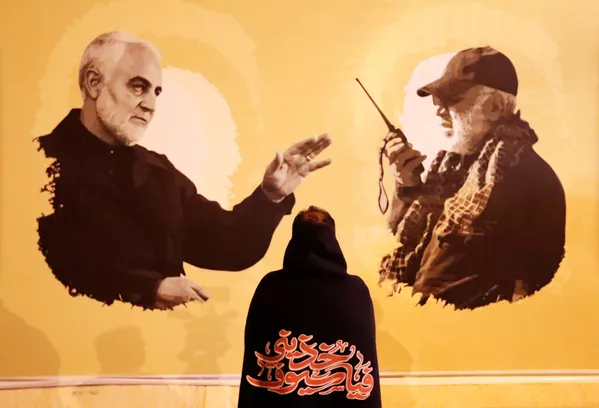 Una mujer observa las fotos de Soleimani y Muhandis a un año de sus muertes. Una mujer observa las fotos de Soleimani y Muhandis a un año de sus muertes. - Sputnik Mundo