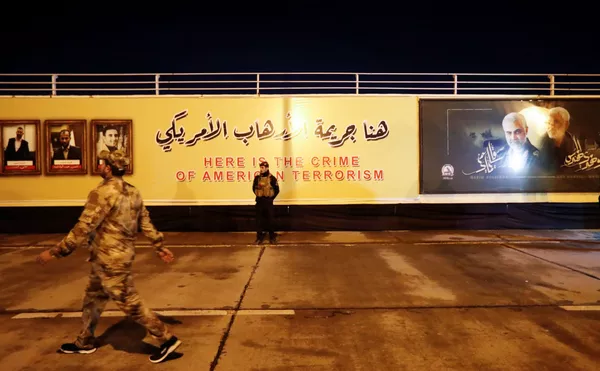 Un miembro de la las Fuerzas de Movilización Popular (PMF) delante de un mensaje que dice: Aquí está el crimen del terrorismo estadounidense, en el aeropuerto internacional de Bagdad. Un miembro de la las Fuerzas de Movilización Popular (PMF) delante de un mensaje que dice: Aquí está el crimen del terrorismo estadounidense, en el aeropuerto internacional de Bagdad. - Sputnik Mundo