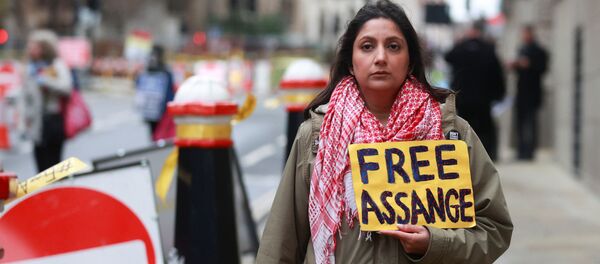 Сторонница основателя WikiLeaks Джулиана Ассанжа держит плакат в его поддержку у Центрального суда в Лондоне - Sputnik Mundo