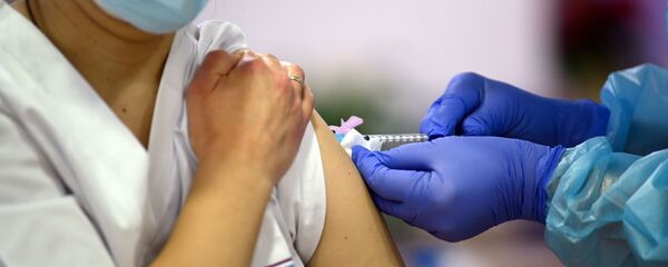 Una trabajadora sanitaria de la residencia de ancianos Los Olmos se vacuna contra el COVID - Sputnik Mundo