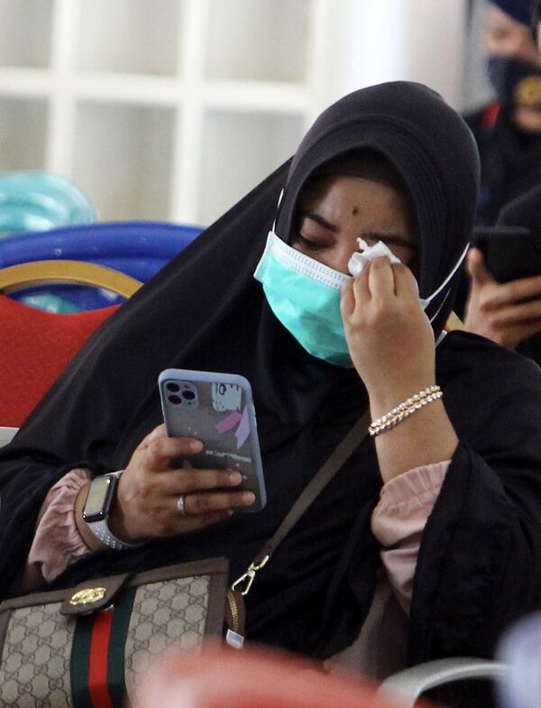 Una familiar de uno de los pasajeros del vuelo SJY182 espera en el Aeropuerto Internacional de Supadio (Indonesia), luego del accidente del avión de Sriwijaya Air. - Sputnik Mundo