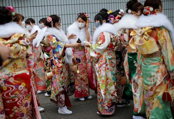 En este día, los oficiales de distrito y municipales invitan a los jóvenes para instruirlos en cómo comportarse como adultos. En la foto: unas chicas con atuendo tradicional en la ceremonia del Día del Adulto en Yokohama.  - Sputnik Mundo