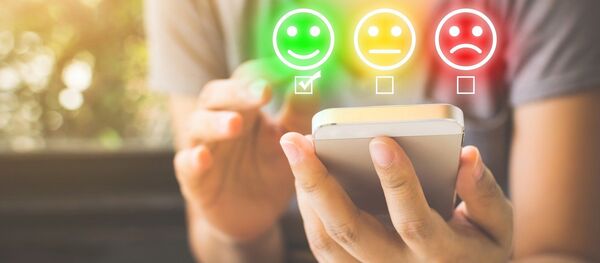 Un teléfono móvil y unos emoticonos - Sputnik Mundo