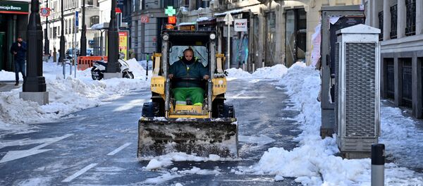 Un operario quita la nieve de la calzada en una céntrica calle de Madrid - Sputnik Mundo