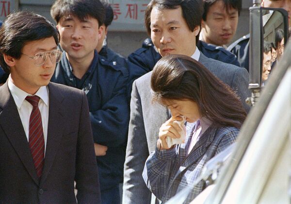La agente norcoreana Kim Hyon-hui, rodeada de cientos de policías, llora sosteniendo un pañuelo mientras entra al Tribunal Superior en Seúl, el 4 de abril de 1989.  - Sputnik Mundo