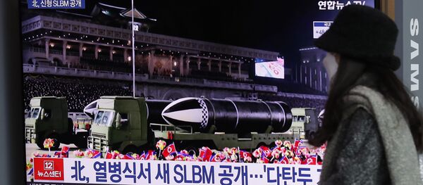 Una mujer ve por la televisión el desfile militar celebrado en Pyongyang  - Sputnik Mundo