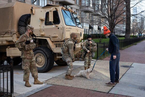 El Departamento de Defensa de EEUU afirmó que el Ejército será investigado por el FBI para prevenir cualquier amenaza de ataque durante la ceremonia de inauguración. En la foto, un camión militar y miembros de la Guardia Nacional en una calle cerca del Capitolio en Washington.  - Sputnik Mundo