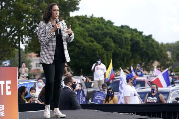 Como una verdadera mujer política, Harris sigue el estilo de 'power dressing'. El principal atributo de su imagen pública es un traje pantalón negro o azul marino. Más a menudo usa uno con pantalones ajustados. Se puede ver a Kamala Harris con zapatillas casi más a menudo que con zapatos.En la foto: la candidata a la vicepresidencia, Kamala Harris, se reúne con los votantes en Miami, Florida, en octubre de 2020. Como una verdadera mujer política, Harris sigue el estilo de 'power dressing'. El principal atributo de su imagen pública es un traje pantalón negro o azul marino. Más a menudo usa uno con pantalones ajustados. Se puede ver a Kamala Harris con zapatillas casi más a menudo que con zapatos.En la foto: la candidata a la vicepresidencia, Kamala Harris, se reúne con los votantes en Miami, Florida, en octubre de 2020. - Sputnik Mundo