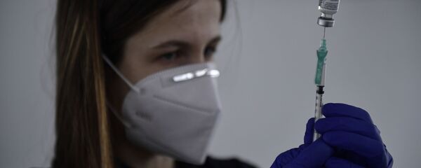 Imagen referencial de una sanitaria suministrando la vacuna de Pfizer en España - Sputnik Mundo